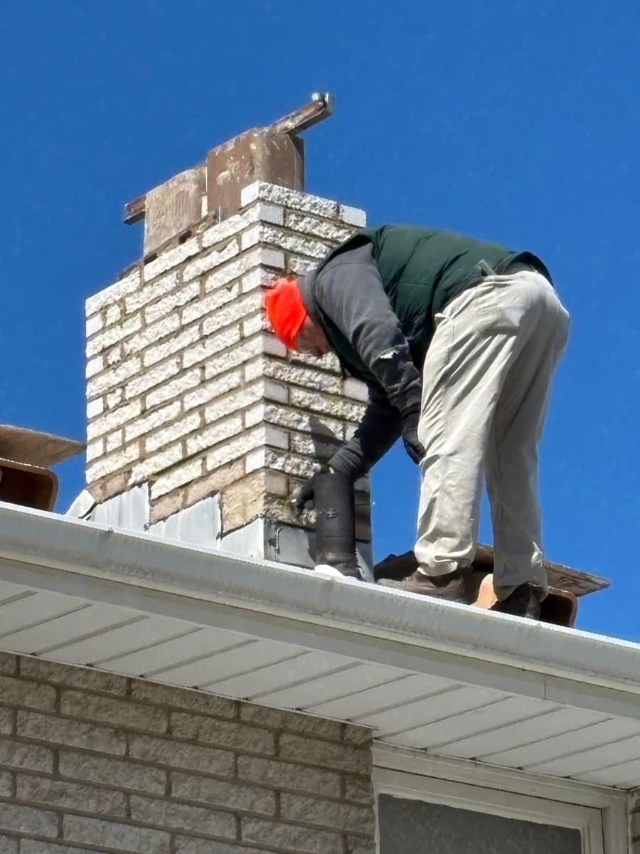 Worker repairing chimney masonry